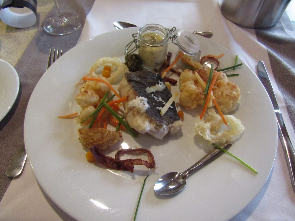 Lomos de bacalao al horno sobre una base de tomate y cebolla en una fuente