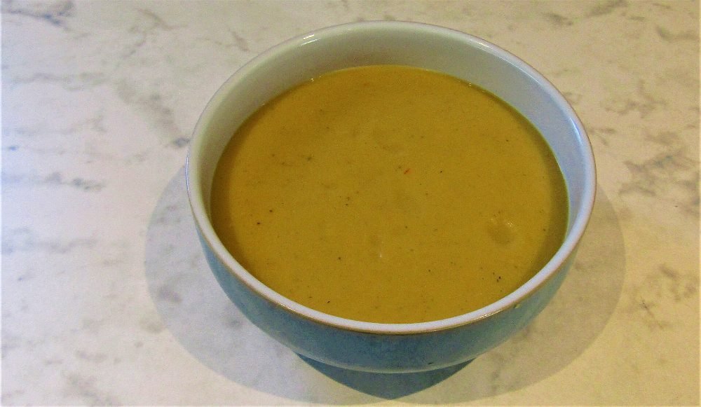 Cuenco de crema de calabaza naranja con semillas de calabaza por encima