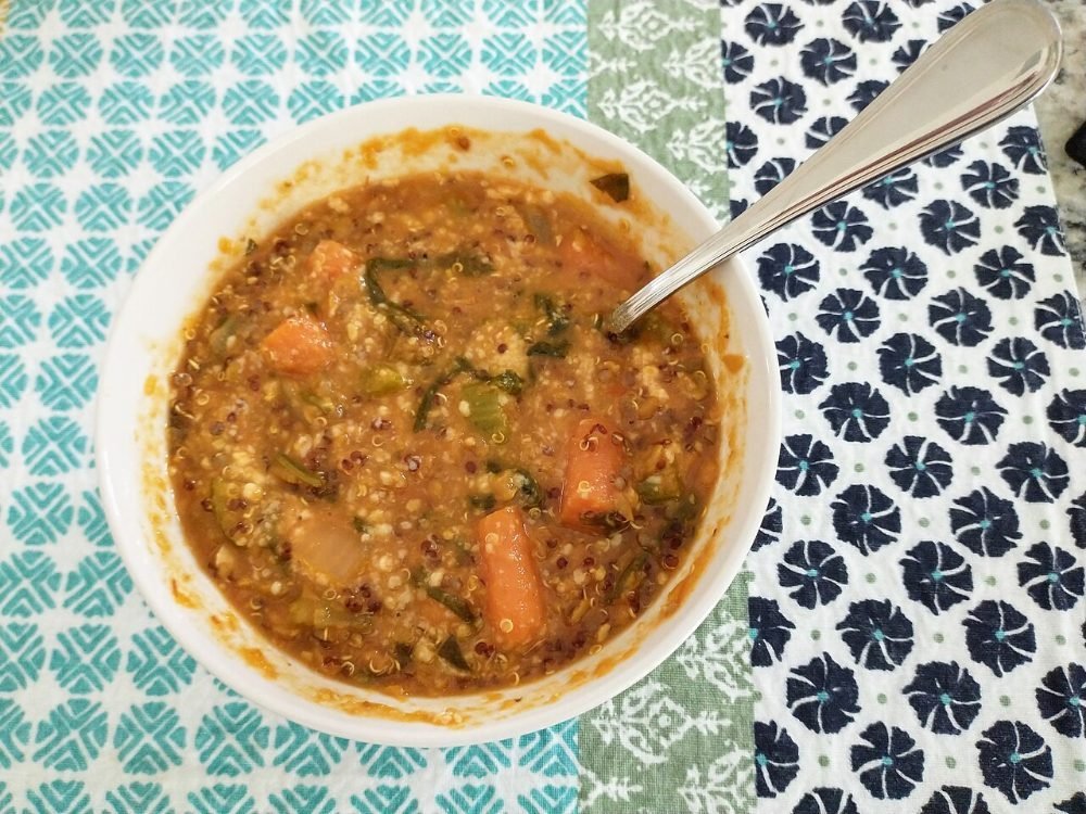 Cuenco de crema de lentejas rojas al curry con cilantro por encima