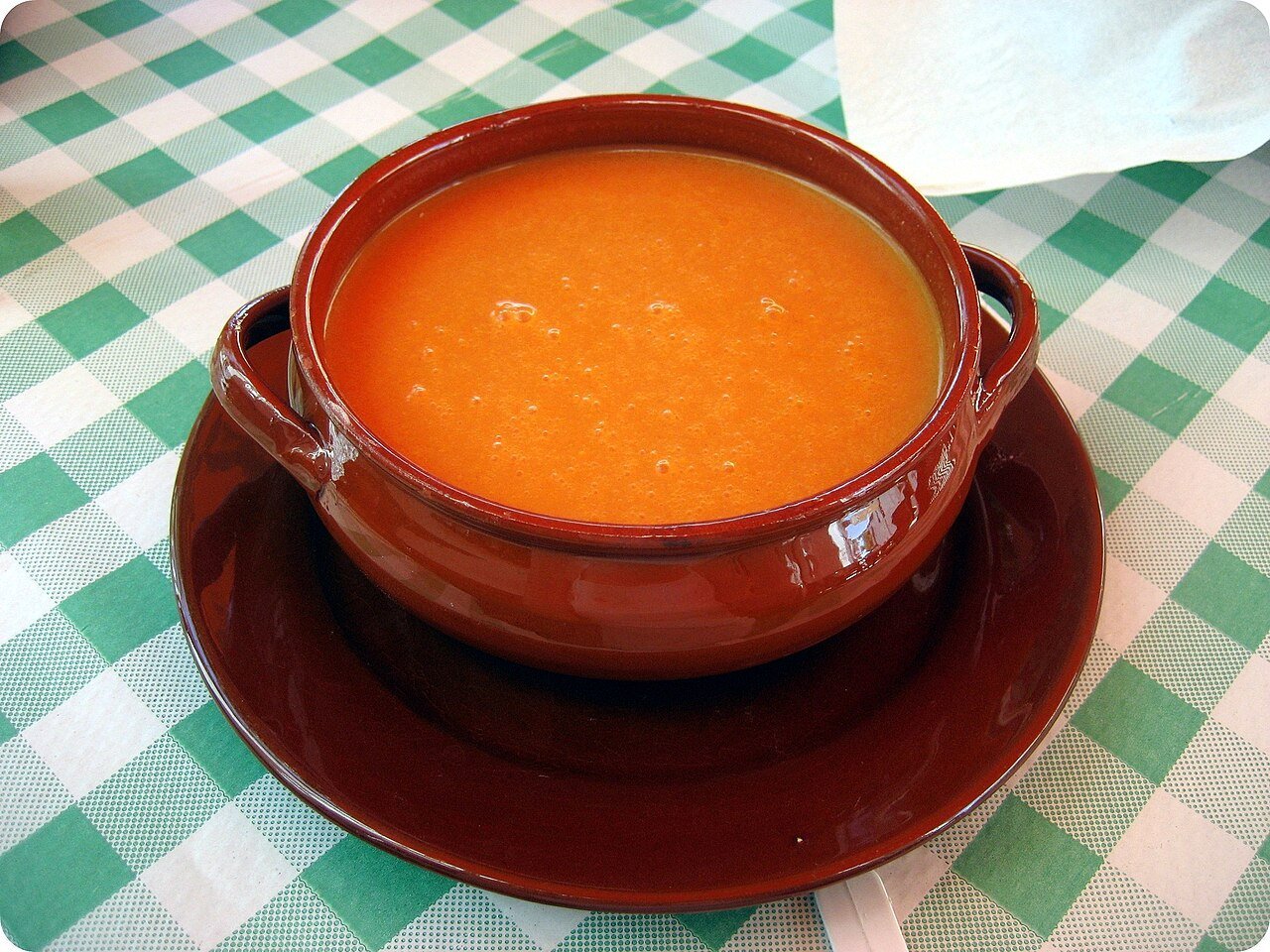 Vaso de gazpacho andaluz con verduras al lado