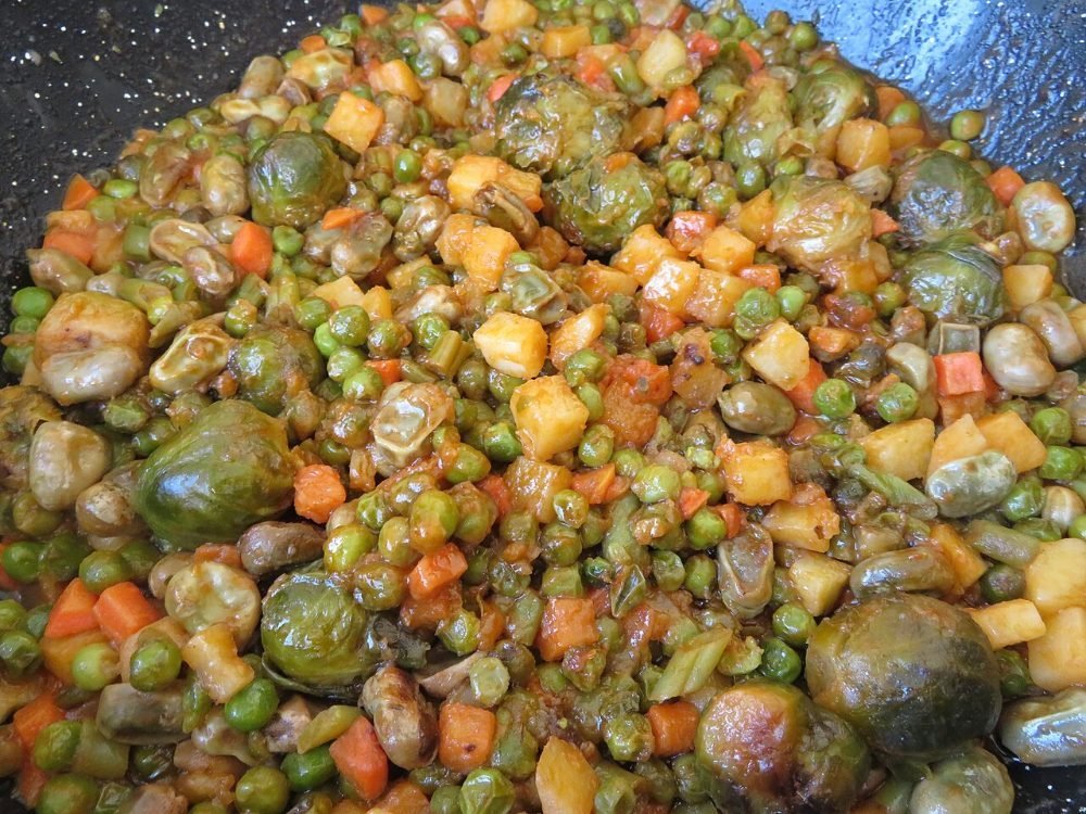 Plato de menestra de verduras con alcachofas, judías verdes y taquitos de jamón