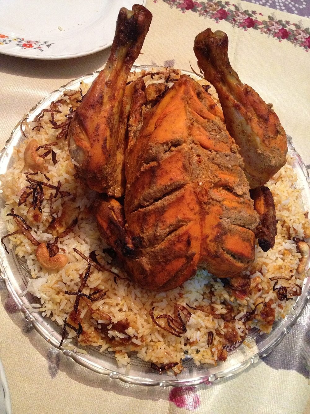 Pollo entero asado y dorado sobre una tabla de madera
