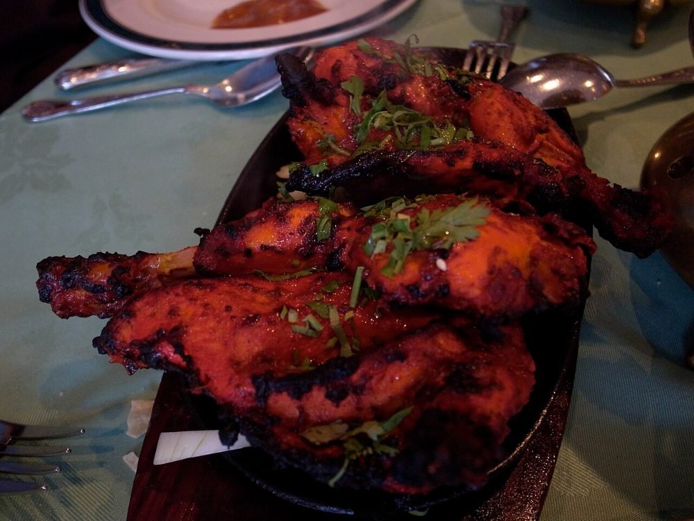 Trozos de pollo marinado en yogur y especias asados en una bandeja