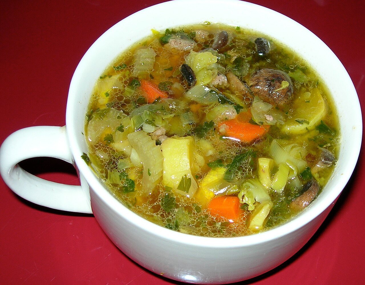 Plato de sopa de verduras con trozos de pollo
